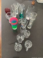 All sixteen assorted shot glasses grouped on countertop
