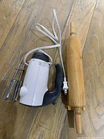 Electric mixer and wooden rolling pin on wood floor