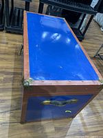 Closed trunk showing blue panels, brown trim, brass corners, side handle