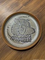 Stoneware charger with incised owl motif, brown rim