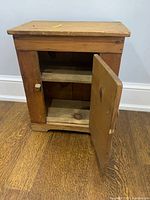 Nightstand with door open revealing interior shelf and wood finish