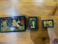 Front view of three Russian lacquer boxes showing painted lids