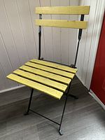 Front view of iron frame chair with yellow wood slats