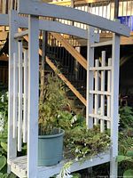 Front view of wood arbor with bench and trellis sides