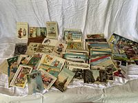 Wide shot showing the full assortment of postcards and greeting cards spread on cloth