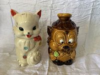 Front view of white cat and brown dog ceramic cookie jars