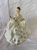 Full view of figurine showing pose, gown, and rose