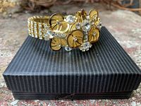 Front angled view of rhinestone floral bracelet on box