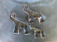 Top view of three clear Kosta Boda glass elephant figurines in graduated sizes