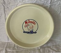 Top view of round white plastic tray showing McDonald's Speedee logo and rim
