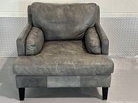 Front view of grey leather lounge chair showing cushions and legs