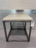 Full view of side table front showing travertine top and steel frame