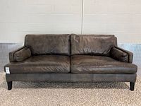 Front view of grey leather sofa showing overall design and condition