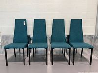 Front view of four teal dining chairs lined up