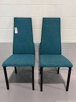 Front view of both teal upholstered dining chairs