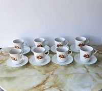 Front view of all 8 cup-and-saucer pairs