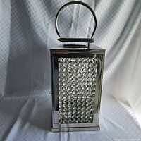 Front view of metal lantern with crystal panels and handle