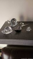 Group shot of five glass snail figurines on shelf