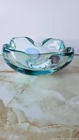 Oblique view of art glass bowl showing wavy rim and color swirls