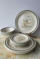 Stacked bowls, plates, dinner plate on stand displaying pattern