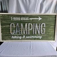 Full view of wooden sign showing all text and arrow