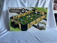 Front of retail box showing tabletop foosball game and features