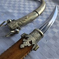 Close-up of hilt, blade base, and scabbard throat detailing