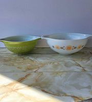 Both Pyrex Cinderella bowls side by side on surface