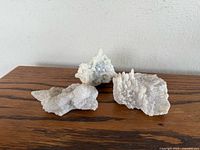 Three quartz clusters on wood surface