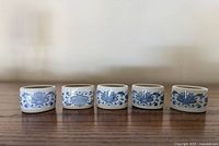 Front view of five blue and white porcelain napkin rings showing floral design