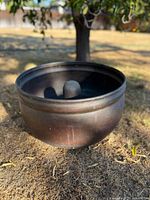 Side view of copper planter showing rolled rim and patina