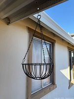 Full view of hanging wrought iron basket on chains