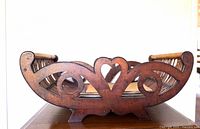 Front view showing carved scroll and heart cutouts and footed base