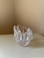 Angled side view showing fluted clear glass petals and footed base