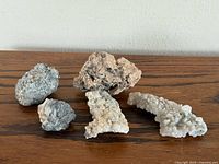 Five mineral specimens on wood surface