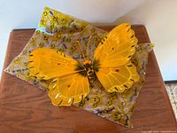 Butterfly resting on smiley-print wrapper showing overall look