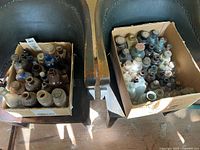 Two boxes filled with assorted vintage glass apothecary bottles
