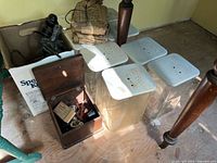Group shot of jars with lids, insulator, handset box, wrapped elements, wooden box of parts