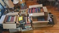 Six boxes filled with assorted books on floor