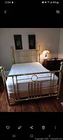 Full view of assembled brass bed frame showing headboard, footboard and mattress for scale