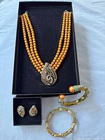 Full set showing necklace, earrings, two bangles in boxes