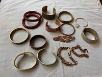 Group shot showing all 14 bracelets laid out on cloth