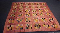 Full view of quilt laid flat showing overall pattern and colours