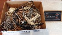 Top view of box showing tangled assortment of wires with varied colors and connectors, stove timer visible adjacent