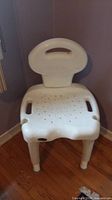 Front view of white plastic shower chair