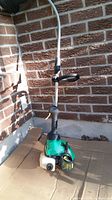Full view of Weed Eater Featherlite FL25C gas trimmer standing upright