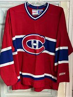 Full front view of red CCM Montreal Canadiens jersey on hanger