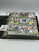 Binder closed showing pages of sleeved football cards