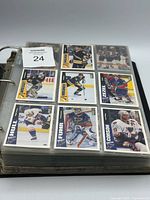 Binder open showing nine-card page with players Brett Hull, Grant Fuhr, Shayne Corson etc.