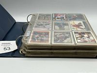 Closed blue binder filled with card pages, side view